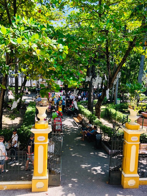 things to do in cartagena, what to do in cartagena, cartagena turismo, tripadvisor cartagena, things to do in Cartagena, colombia, plaza bolivar, yellow gate entrance to a lush green park with people