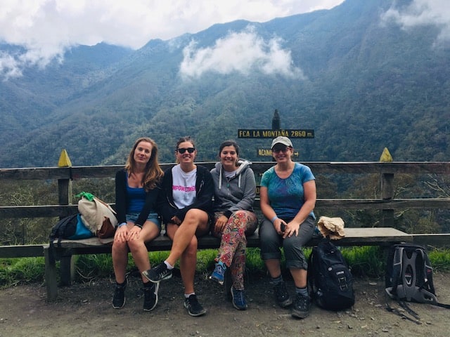 things to do in salento, salento colombia, cocora valley, valle de cocora, finca la montana, 4 women, 4 women on a bench in front of a mountain