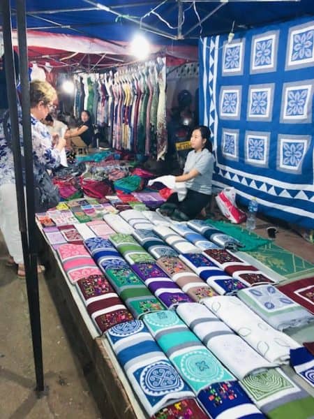 things to do in Luang Prabang, what to do in luang prabang, luang prabang province, unesco world heritage, night market, luang prabang night market, woman selling fabric in a market