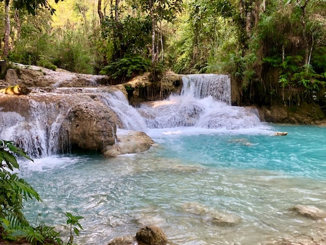 beautiful small waterfall into a green pool, luang prabang, laos, kuang si waterfall, luang prabang waterfall, kuang si falls, things to do in luang prabang, laos waterfall