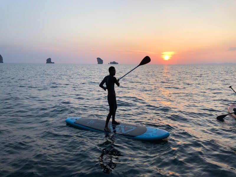 krabi sunset, thailand cruise, krabi sunset cruises, man on a paddleboard, man on a paddleboard swatting the sun with his paddle, sunset, thailand sunset