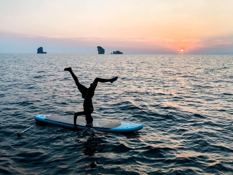 krabi sunset cruises, sunset cruise, best things to do in thailand, best plances to go in thailand, thailand must see, man doing a headstand on a paddleboard