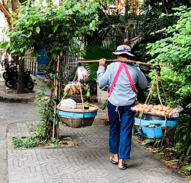 man carrying groceries, man carrying two bundles across his back, bangkok, bangkok street vendor