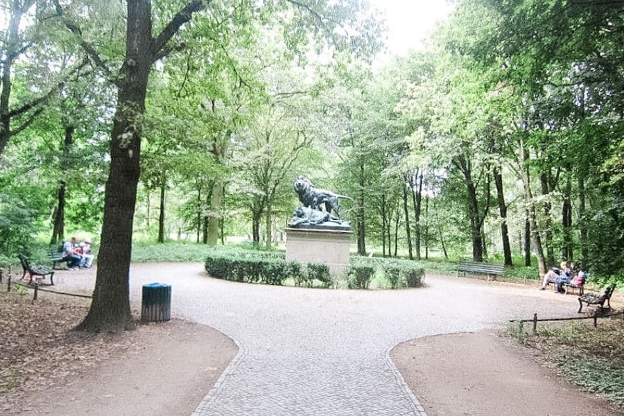 tiergarten, path in the woods with a statue of a lion