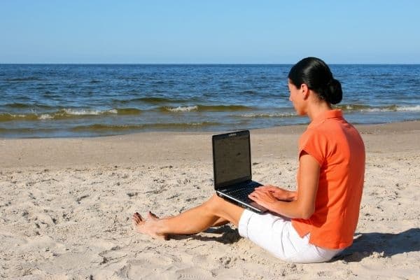 woman working from laptop on the beach, remotely working, remote work, worf from home, part time remote jobs, wfh jobs, remote working jobs, remote jobs online, digital nomad jobs, working nomads, telework jobs, telecommute jobs, remote jobs from home, fully remote jobs, working remotely from home, work from home business, let's work remotely, fully remote jobs, work from home solutions