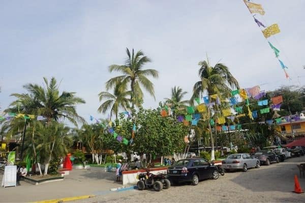 street in sayulita, colorful flag banners, puerto vallarta to Sayulita