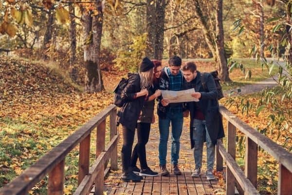 friends looking at a map to plan their hike, preparation for hiking, beginner hiking tips, hiking guide for beginners