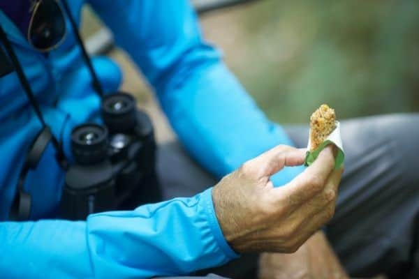 man eating a snack on the hiking trail, start hiking, hiking essentials for beginners, beginner hiking tips