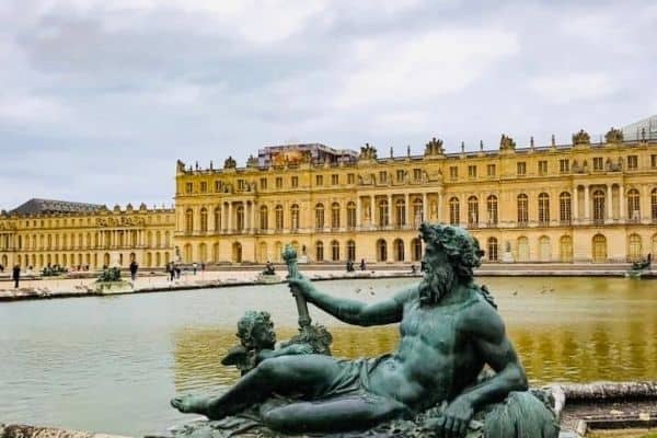 statue in front of the palace of versailles, france