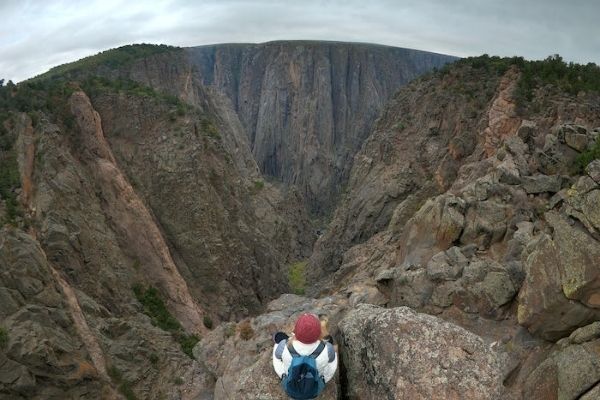 standing on the edge of the rock in black canyon national park, black canyon colorado, black canyon national park, black canyon in colorado