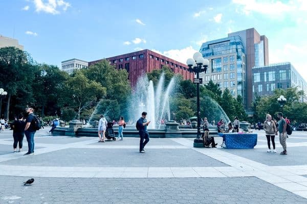fountain with people hanging around talking in washington square park