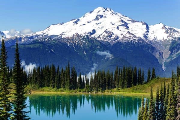 snow capped mountain, green lake, tall evergreen trees, national parks in washington