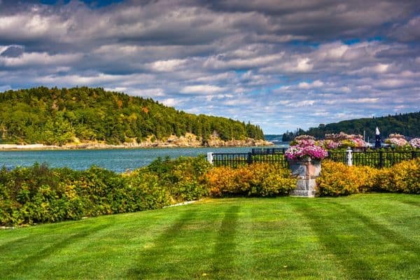 view of frenchman bay, green grass, water below, acadia national park lodging, hotels in acadia national park, where to stayin acadia national park