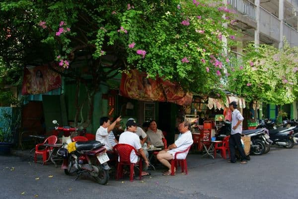 group of vietnamese men sitting outside a cafe in ho chi minh city