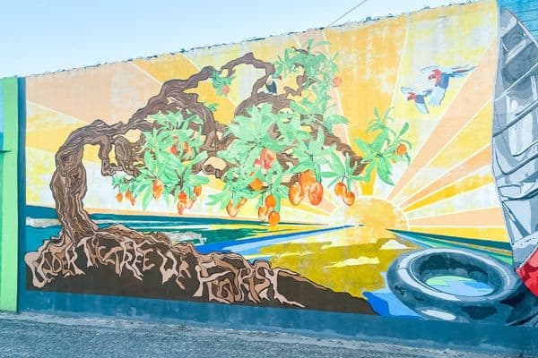mural of a colorful tree with a bird flying away