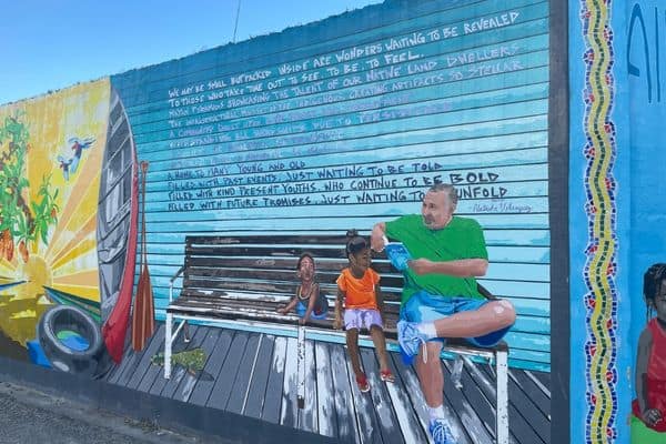 mural of man and two children sitting on a bench