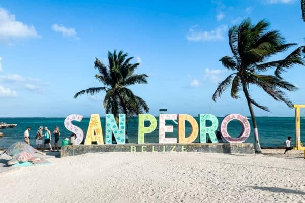 big san pedro belize sign letters in the sand, palm trees and water in the background, san pedro ambergris caye, ambergris caye belize, belize san pedro, belize city to san pedro