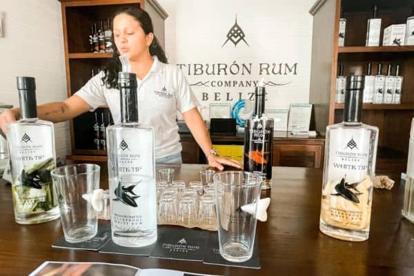 bartender at tiburon rum company, different liqours out for tasting, san pedro town