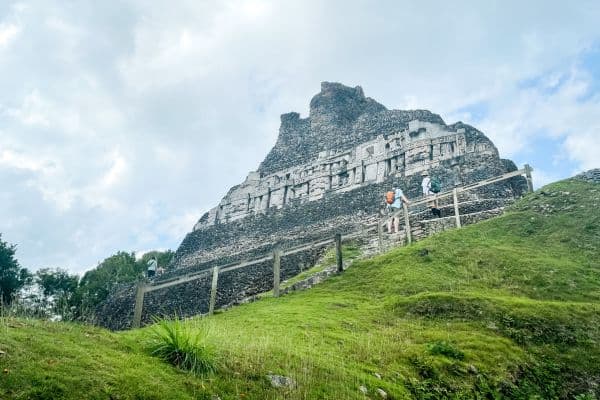 people going up the small walkway to the tempple, grassy hills with the temple at the top