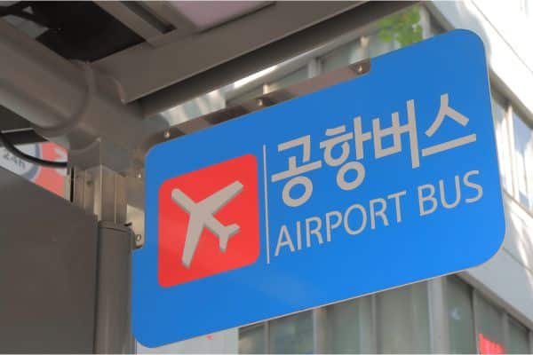 blue and red sign showing where the airport bus is, english and korean translation, seoul neighborhoods, best area to stay in seoul
