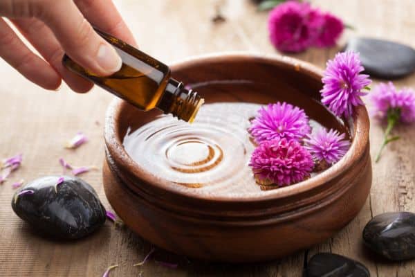 someone adding drops of essential oil to a bowl with flowers floating inside, dublin spa day, best spas dublin, spa day dublin, dublin spa breaks
