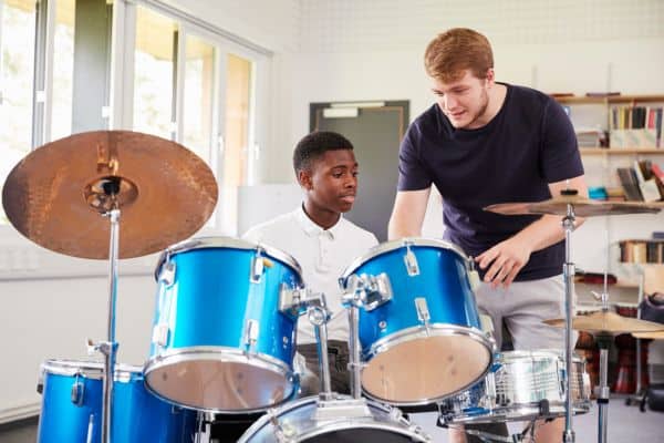 man teaching boy to play the drums, great side hustles, how to start a side hustle