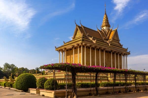 oudoing temple, shrubs with pink flowers growing around the temple, sunny blue skies, day trips from phnom penh