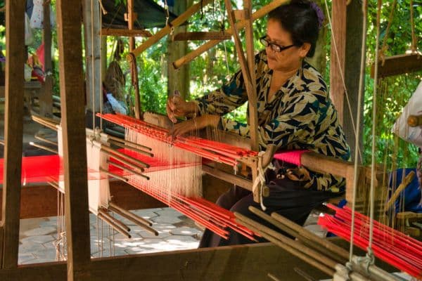 woman weaving silk on a traditional loom, phnom penh day trips, phnom penh itinerary 