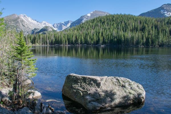 rocky mountain national park, beautiful lake with pine trees and snow capped mountains