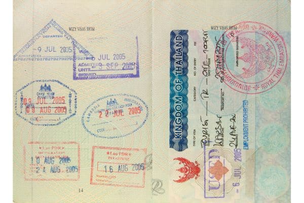 passport page in a passport with thailand visa on one page and many stamps on the other page