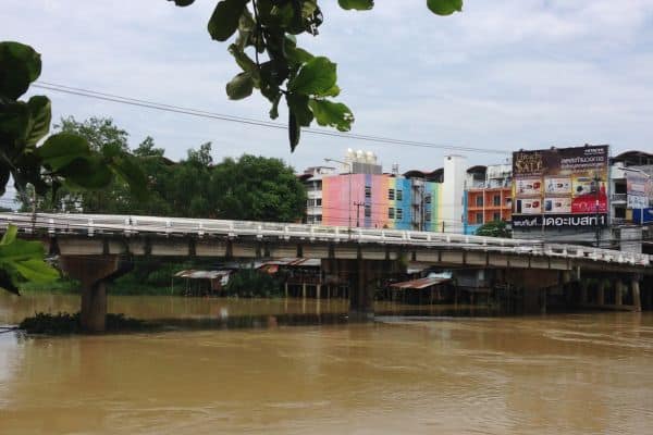 chanthaburi waterfront community, bridge crossing over the river. buildings in the distance 
