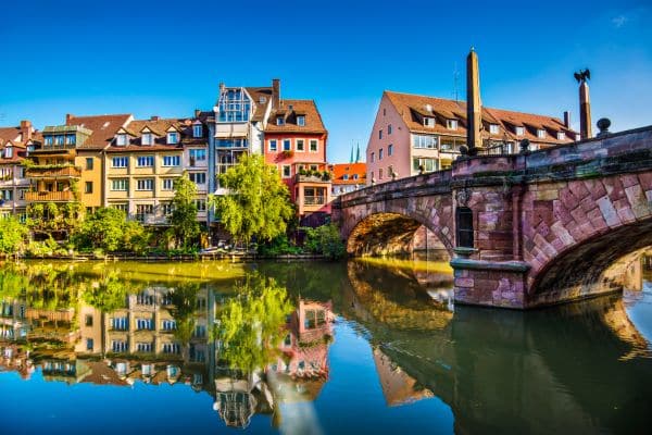 colorful view of the city of nuremberg, bridge gping over the river, typical bavarian architecture buildings behind the bridge, weekend trips from munich, munich day trips, day trips from munich by train