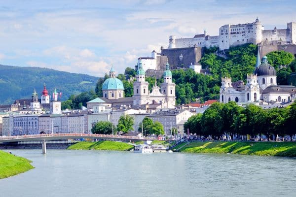salzburg austria, river with cityscape on the side, green covered hills in the background, day trips from munich by train, munich to salzburg day trip, weekend trips from munichsazburg day trips from munich