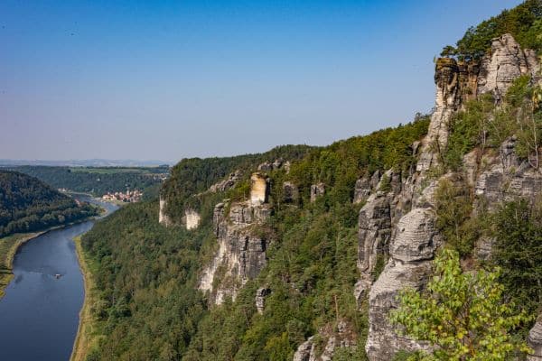 mountains in saxon switzerland, cliffs overlooking the winding river, greenery and plants growing from the cliff