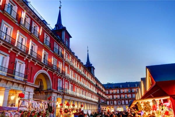 red building in centro madrid, spanish architecture, people in the streets walking and shopping