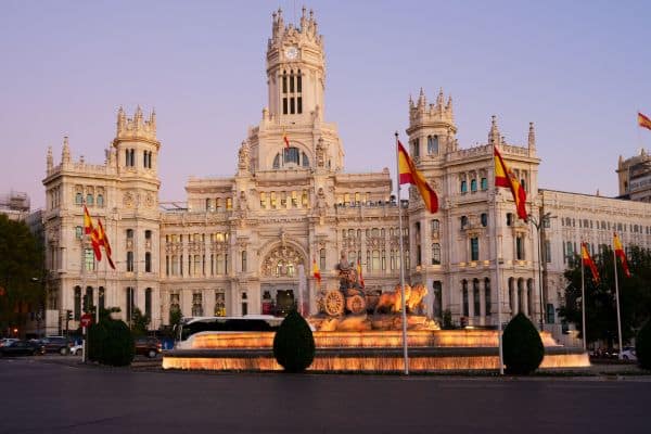 government building in spain, spanish flags flying on poles outside the building, where to stay in madrid, hotels in madrid central, best places to stay in madrid