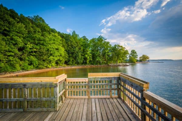 pier overlooking lake normam, clear skies with a few clouds, trees and shoreline on the left side 