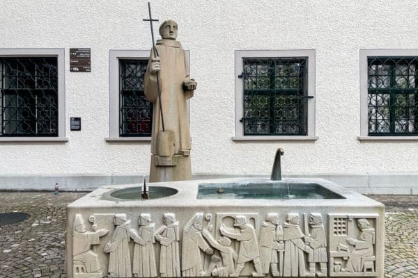 fresh water fountain in st gallen, ststue of a saint holding s cross